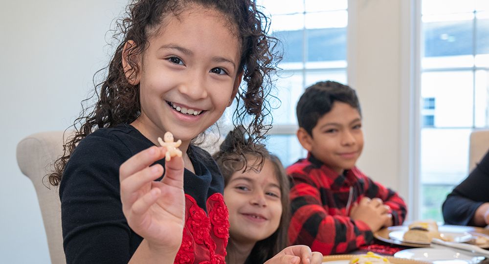 Jennifer Rosales, 7, enseña la figura plástica que encontró en su trozo de rosca de reyes, el 16 de diciembre, en su hogar de Garland.