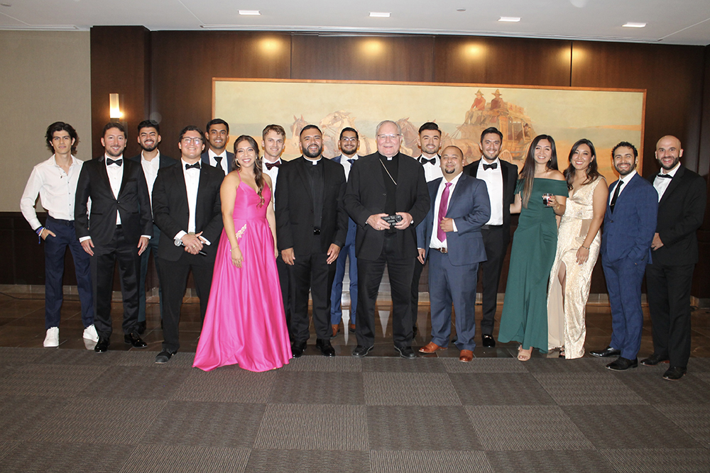 El obispo Edward J. Burns (centro) y el padre Ignacio Olvera (Izq), posan con miembros del Faith Fitness Ministry, en la gala de aniversario celebrada el 1 de septiembre en Dallas.
