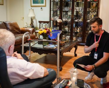 Evan Taylor, right, a pastoral visitor at St. Rita Catholic Community, prays with Dr. James Moorman during a pastoral visit on June 26. (Amy White/The Texas Catholic)