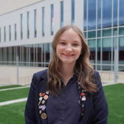 Ursuline Academy of Dallas graduate smiles as she stands on her school's campus