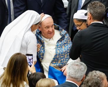 Pope Francis smiles as religious sisters greet him at the end of his weekly general audience Aug. 21, 2024, in the Paul VI Audience Hall at the Vatican. (CNS photo/Lola Gomez)