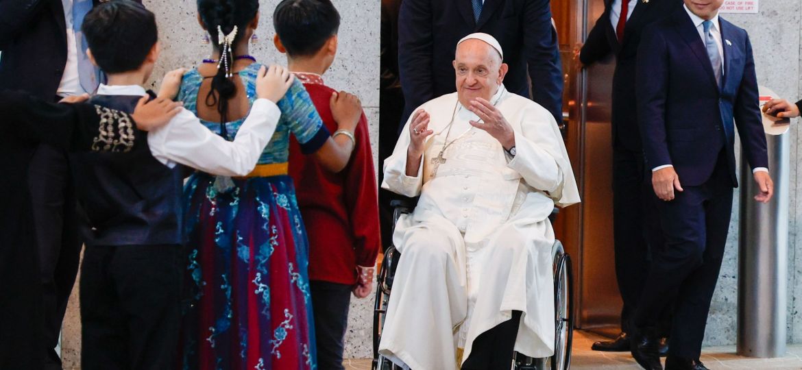 Pope Francis greets a group of children as he arrives in Singapore.