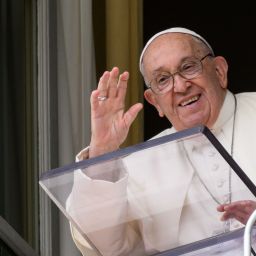 Pope Francis waves to visitors gathered in St. Peter's Square.