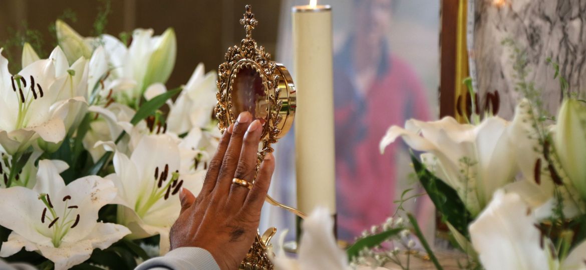 A pilgrim touches the reliquary containing a relic of the heart of Blessed Carlo Acutis.