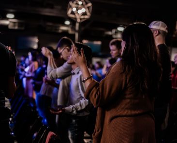 Young adults raise their hands in praise.