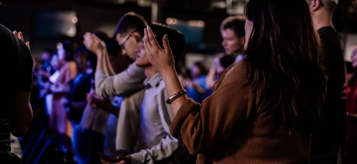 Young adults raise their hands in praise.