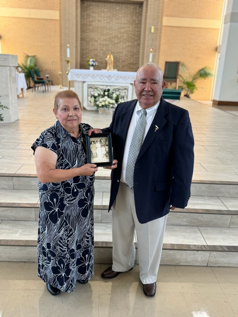 Herminia y Pedro Dávila enseñan una foto de su matrimonio hace 54 años en Ocampo, Guanajuato, México. La pareja posa en la Iglesia de Santa Cecilia, el 24 de agosto cuando recibieron una bendición especial por su aniversario.