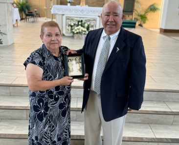 Herminia y Pedro Dávila enseñan una foto de su matrimonio hace 54 años en Ocampo, Guanajuato, México. La pareja posa en la Iglesia de Santa Cecilia, el 24 de agosto cuando recibieron una bendición especial por su aniversario.