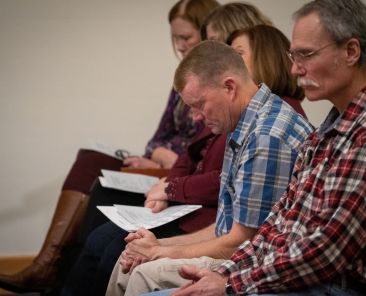 Doug DeVore, center, bows his head in prayer during the Service of the Longest Night held at St. Meinrad Archabbey in St. Meinrad, Ind., Dec. 14, 2019. DeVore attended the service, which was held for those grieving during the holiday season, to honor his late father, John. (Catholic News Service)