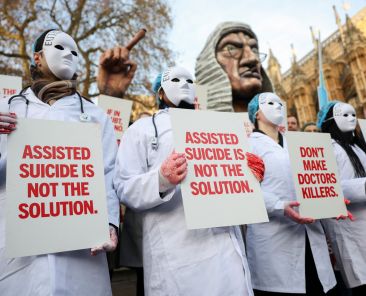 Protestors holds a placard outside Parliament as British lawmakers debate the assisted dying law in London Nov. 29, 2024. Britain's lawmakers voted Nov. 29 to legalize assisted suicide for the terminally ill in England and Wales, despite opposition from Britain's Catholic bishops and other faith groups. (OSV News photo/Mina Kim, Reuters)