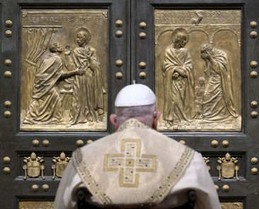 Pope Francis pauses in prayer before knocking on the Holy Door of St. Peter's Basilica at the Vatican Dec. 24, 2024, to open it and inaugurate the Holy Year 2025. (CNS photo/screen grab, Vatican Media)