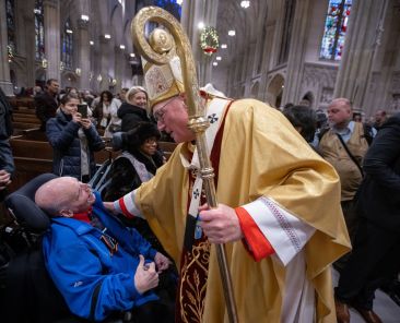 Cardinal Timothy M. Dolan greets a man after celebrating Mass at St. Patrick's Cathedral in New York City. The Dec. 29, 2024, Mass marked the kickoff of the 2025 Jubilee year, with similar celebrations taking place in diocese across the U.S. and around the world. (OSV News photo/Jeffrey Bruno)