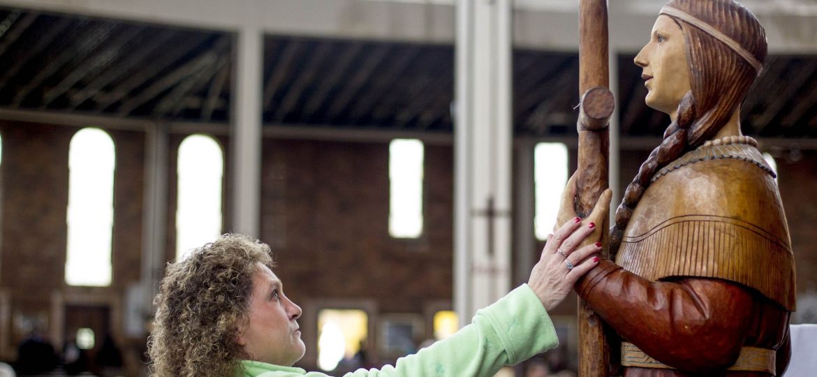 WOMAN TOUCHES STATUE OF NEW NATIVE AMERICAN SAINT DISPLAYED DURING MASS IN HER HONOR AT NEW YORK SHRINE