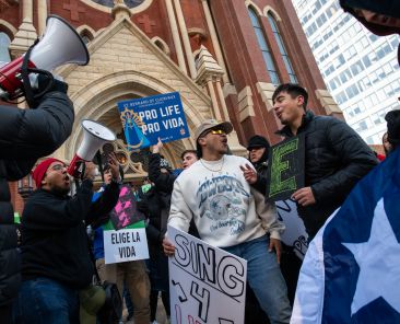 Matthew Sierra, 22, center, and Andrew Prado, 20, right, of St. Bernard Clairvaux parish, sing and dance as they chant pro life slogans before the start of this year's North Texas March for Life from the National Shrine of Our Lady of Guadalupe to City Hall in downtown Dallas, on Jan. 20, 2024.