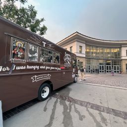 A "Capuchin Family Kitchen" food truck is parked outside the Pasadena Convention Center.