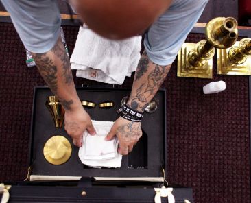 An inmate puts away the items used on the altar following Mass at the Ellsworth Correctional Facility in Kansas. (OSV News photo/Karen Bonar, The Register)