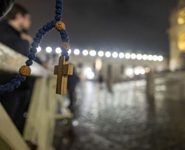 A rosary can be seen as people join Cardinal Pietro Parolin, Vatican secretary of state, in reciting the rosary for Pope Francis in St. Peter's Square at the Vatican Feb. 24, 2025. Cardinals living in Rome, leaders of the Roman Curia and the faithful joined the nighttime prayer. (CNS photo/Pablo Esparza)