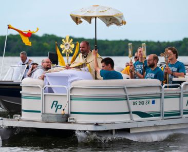 Father Michael Thiel, diocesan chaplain for the National Eucharistic Pilgrimage, is joined by perpetual pilgrims on a pontoon boat on Shawano Lake near Cecil, Wis., during a one-hour Eucharistic boat procession June 12, 2024. The perpetual pilgrims disembarked the boat and walked to Camp Tekakwitha, a youth summer camp owned by the Diocese of Green Bay, where they spent the evening. On March 4, 2025, National Eucharistic Congress Inc. announced the "perpetual pilgrims" of the 2025 National Eucharistic Pilgrimage's Drexel Route. The route is scheduled to begin Pentecost Sunday, May 18, following a Mass of thanksgiving in Indianapolis. It will cover several Southwestern states and end in Los Angeles on the feast of Corpus Christi June 22. (OSV News photo/Sam Lucero)