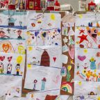 Drawings for Pope Francis cover the base of a statue of St. John Paul II outside Rome's Gemelli hospital March 8, 2025. (CNS photo/Pablo Esparza)