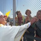 Bishop Mark J. Seitz of El Paso, Texas, is pictured in a file photo touching the hands of people in Mexico through a border fence following Mass in Sunland Park, N.M. Bishop Seitz called for a protest against Trump administration mass deportations, with the demonstration set to take place in El Paso, Texas, March 24, 2025, the feast of St. Oscar Romero, and attended by an international delegation of bishops. (OSV News photo/Bob Roller)