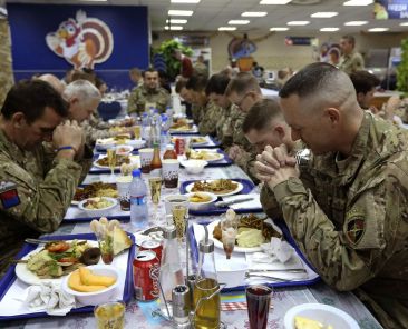 A file photo shows U.S. troops praying before eating a Thanksgiving meal at a NATO base in Kabul, Afghanistan. (OSV News photo/Omar Sobhani, Reuters)
