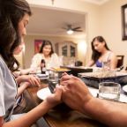 A family is pictured in a file photo praying around the dinner table. (OSV file photo/courtesy Archdiocese of Detroit)