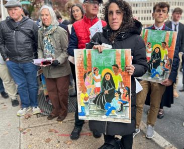 Una mujer que asistió a la vigilia de oración y procesión eucarística por los inmigrantes celebrada el 13 de noviembre de 2025 frente a la Oficina de Inmigración y Aduanas de Filadelfia, sostiene una imagen de Santa Francisca Javier Cabrini, patrona universal de los inmigrantes, cuya festividad se eligió para conmemorar la ocasión. La vigilia fue una de las varias que se celebraron ese día en todo el país como parte de la iniciativa “Una Iglesia, una familia”, un esfuerzo popular puesto en marcha por varias entidades católicas. (Foto de OSV News/Gina Christian)