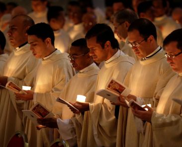 Priests hold candles as they wait for Pope Francis to arrive for Mass with consecrated women and men marking the feast of the Presentation of the Lord and the World Day for Consecrated Life in St. Peter's Basilica at the Vatican Feb. 2, 2018. (CNS photo/Max Rossi, Reuters)