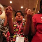 Navajo Dawn Hale, 12, of Tohatchi, N.M., holds hands with other Tekakwitha Conference attendees July 24 as they pray the Our Father during Mass in Fargo, N.D. The gathering of Native American Catholics, held July 23-27, marked its 75th anniversary. (CNS photo/Nancy Wiechec) (July 25, 2014) See TEKAKWITHA-OPENING July 25, 2014.