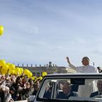 Pope Leo XIV waves to the crowd as some people hold aloft yellow balloons before leading his general audience in St. Peter's Square at the Vatican Feb. 18, 2026. (CNS photo/Vatican Media)