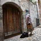 A woman prays at a locked door blocking her entrance to the Church of the Holy Sepulcher in the Old City of Jerusalem March 4, 2026, on day five of the U.S.-Israel war with Iran. The church and other religious sites as well as stores were locked shut by order of the Israeli government as Iranian ballistic missiles were fired at Israel. (OSV News photo/Debbie Hill)