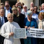 Pope Leo XIV poses with former classmates who graduated from the lower school of St. Mary of the Assumption in Chicago in 1969 after the general audience in St. Peter's Square at the Vatican March 18, 2026. He is holding their eighth-grade graduation class photo. (CNS photo/Vatican Media)