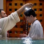 El padre Ignacio Olvera administra el Sacramento del Bautismo durante la Vigilia Pascual en la parroquia Santa Clara de la Diócesis de Dallas, el 4 de Abril del 2026.