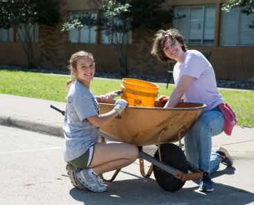 University of Dallas student (rt) Sophie Del Mazo participated in the UD Big Event service day and volunteered at Faustina Academy in Irving on Saturday morning where she helped Faustina Academy Student Kate Fontenot clean around the school building.