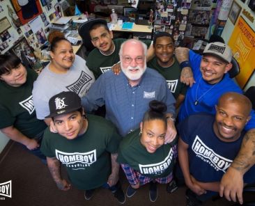Jesuit Father Greg Boyle, founder of Homeboy Industries in Los Angeles, poses for a photo with trainees in this undated photo. The acclaimed gang-intervention program in Los Angeles has a $100 million fundraising campaign for its expansion started with an initial $10 million from Frank McCourt Jr., a billionaire Georgetown University alumnus and founder of Georgetown's McCourt School of Public Policy. The capital drive was promoted at a June 12, 2026, summit held at the McCourt School. (OSV News photo/courtesy Homeboy Industries)