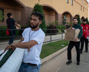 Jose Gutierrez, left, David Monjaraz and Ismael Contreras, work together to load donations for the victims of an apartment explosion, on Sunday, May 31, 2026 at the Blessed Sacrament Catholic Parish in Dallas. (BEN TORRES/Special Contributor)