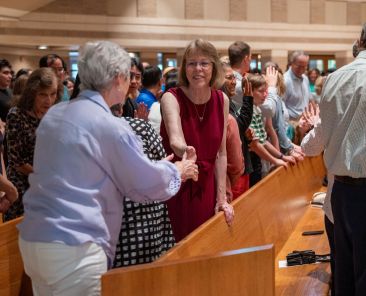 Parishioner give the sign of peace before receiving the Eucharist during Communion at the 50th Anniversary Mass for St. Joseph Catholic Church, on June 06, 2026 at the parish in Richardson.