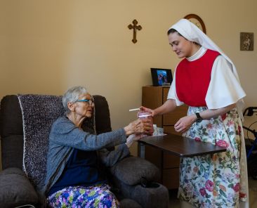 An undated file photo shows a Dominican Sister of Hawthorne serving a resident at Rosary Hill Home in New York. On July 30, 2026, a judge temporarily shielded four orders of women religious and Catholic healthcare ministries from enforcement of a New York state law allowing physicians to aid terminally ill adults in dying by suicide. (OSV News photo/courtesy Becket)
