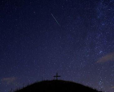 A meteor streaks past stars in the night sky in Grossmugl, Austria, Aug. 13. (CNS photo/Heinz-Peter Bader, Reuters)