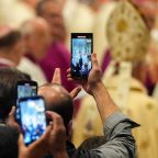 People raise their phones to capture images as cardinals process at the beginning of the Mass on the ninth day of official mourning for Pope Francis at the Altar of the Confession in St. Peter’s Basilica at the Vatican May 4, 2025. (CNS photo/Lola Gomez)