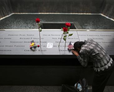 A woman grieves at the inscription of her late husband's name at the national 9/11 Memorial and Museum in New York City Sept. 11, 2014. Twenty-five years after the 9/11 terrorism attacks that claimed the lives of nearly 3,000 people, Catholic family members who lost loved ones that day have credited their faith with getting through the losses. (OSV News photo/Chang Lee, Reuters)