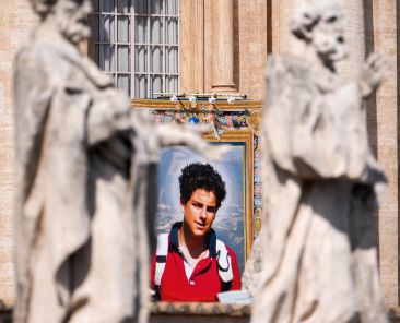 A tapestry depicting St. Carlo Acutis hangs from the facade of St. Peter’s Basilica during a canonization Mass at the Vatican Sept. 7, 2025. (CNS photo/Lola Gomez)