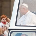 Pope Leo XIV greets a child from the popemobile while riding around St. Peter’s Square at the Vatican before his weekly general audience Oct. 21, 2026. (CNS photo/Lola Gomez)