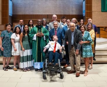 Joseph Lucido, center, with Fr. Jude Chukwuma and the Lucido family after a sensory friendly Mass at St. Patrick, on October 11, 2026. Joseph has cerebral palsy. Ben Torres for the Texas Catholic